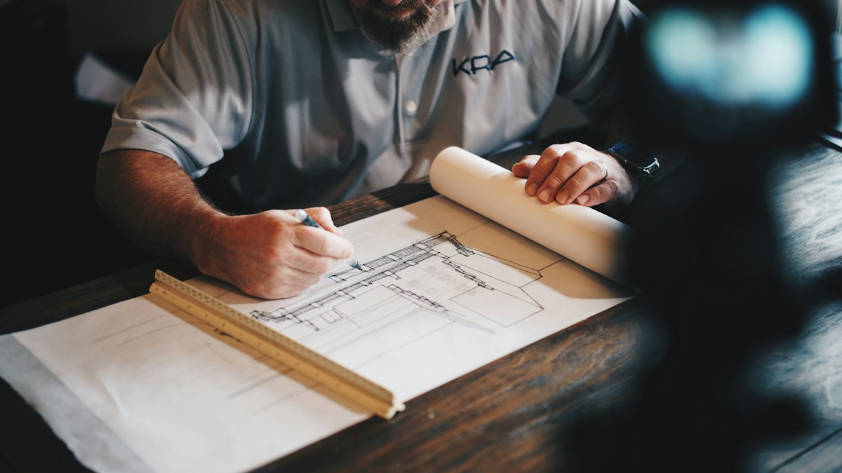 Profissional desenhando planta de projeto